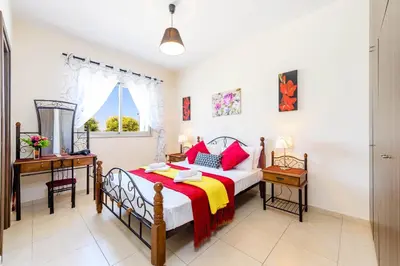 a bedroom with a bed and a desk and a window at Villa Marizan in Protaras