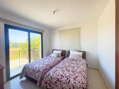 a bedroom with two beds and a large window at Villa Chrysa in Protaras