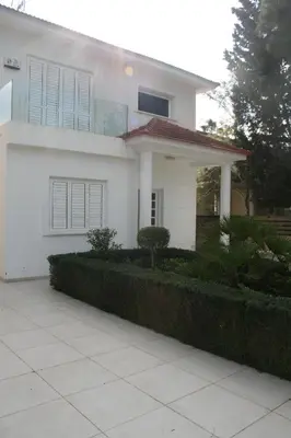 a white house with a hedge in front of it at Serenity Villa Mediterranean in Pervolia