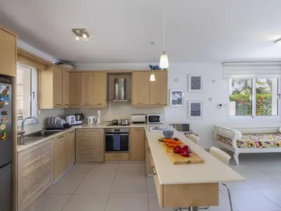 a kitchen with wooden cabinets and a counter top at Passion Villa in Protaras