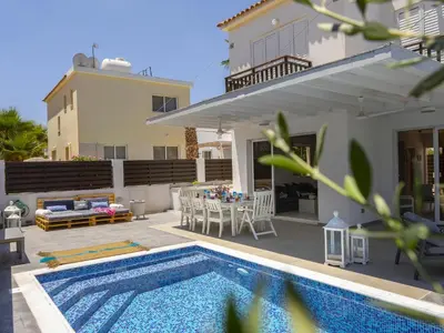 a villa with a swimming pool in front of a house at Passion Villa in Protaras