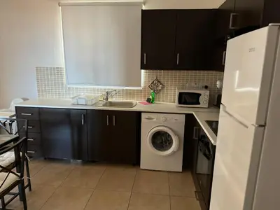 a kitchen with a sink and a washing machine at Apartment at luxurious Mythical Sands Resort in Paralimni