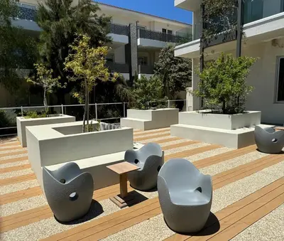 a courtyard with chairs and tables in front of a building at Apartment at luxurious Mythical Sands Resort in Paralimni