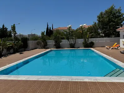 a swimming pool in the middle of a house at Apartment at luxurious Mythical Sands Resort in Paralimni