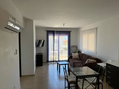 a living room with a couch and a table at Apartment at luxurious Mythical Sands Resort in Paralimni
