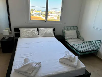 a bedroom with a bed with towels on it at Apartment at luxurious Mythical Sands Resort in Paralimni