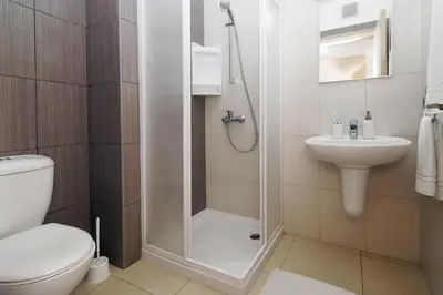 a bathroom with a shower and a toilet and a sink at Calypso - Coralli Beachfront Apartment in Protaras