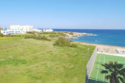 a view of a beach with a soccer goal at Calypso - Coralli Beachfront Apartment in Protaras