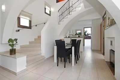 a dining room with a table and chairs and stairs at Villa Ingrid in Ayia Napa