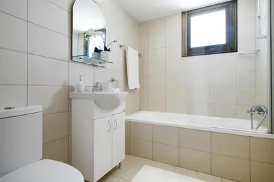 a bathroom with a tub and a toilet and a sink at Villa Ingrid in Ayia Napa