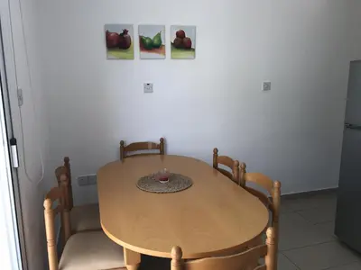 a wooden table and two chairs in a room at Villa Nissi Beach 28 in Ayia Napa