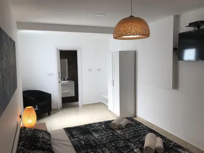 a bedroom with a bed and a living room at Villa Nissi Beach 28 in Ayia Napa