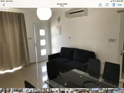 a living room with a couch and a glass table at Villa Nissi Beach 28 in Ayia Napa
