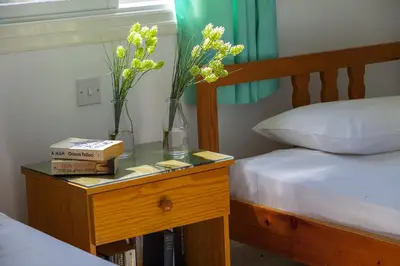 two vases with flowers on a table next to a bed at Protaras Holiday Suite Annie in Protaras
