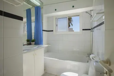 a bathroom with a tub and a toilet and a sink at Protaras Holiday Suite Annie in Protaras
