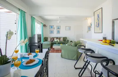 a kitchen and living room with a table and chairs at Protaras Holiday Suite Annie in Protaras