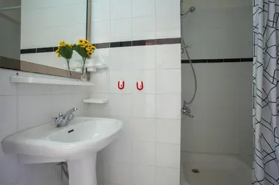 a white bathroom with a sink and a shower at Protaras Holiday Suite Annie in Protaras