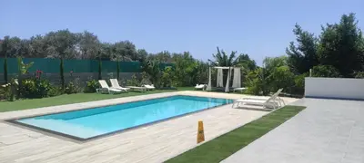 a swimming pool in a yard with chairs and a fence at Kiti Village Villa, Cyprus, salt-water pool, 5 bedrooms, Larnaca in Kiti