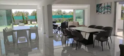 a dining room with tables and chairs and windows at Kiti Village Villa, Cyprus, salt-water pool, 5 bedrooms, Larnaca in Kiti
