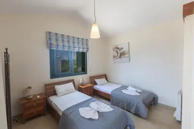 a bedroom with two beds and a window at Spetses Villa 5 in Protaras