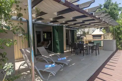 a patio with a table and chairs under a pergola at Spetses Villa 5 in Protaras