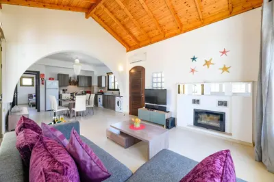 a living room with a couch and a fireplace at Kymma Villa #16 in Ayia Napa