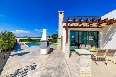 a patio with a table and chairs next to a house at Kymma Villa #16 in Ayia Napa