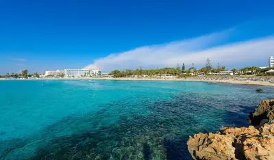 a view of a beach with a resort in the background at Kymma Villa #16 in Ayia Napa