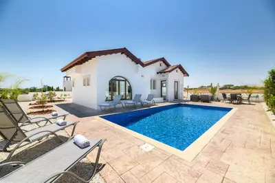 a villa with a swimming pool in front of a house at Kymma Villa #16 in Ayia Napa