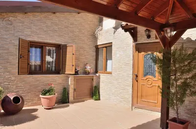 a house with a wooden door and a patio at The Love Holiday House in Tris Elies