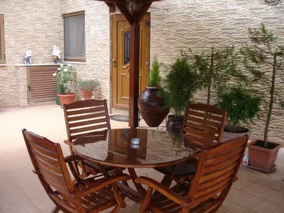 a patio with a table and chairs and potted plants at The Love Holiday House in Tris Elies