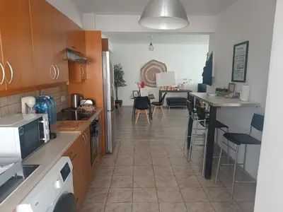 a kitchen with wooden cabinets and a dining room at Markora Central Apartment in Nicosia