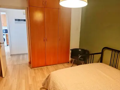 a bedroom with a bed and a cabinet and a chair at Markora Central Apartment in Nicosia