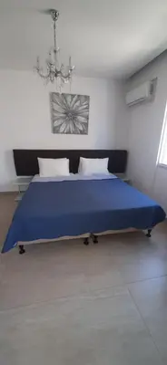 a large blue bed in a white room at P L PANAGIOTIS Apartment in Larnaka
