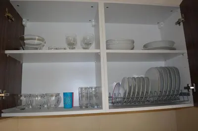 a cabinet filled with glasses and plates and dishes at P L PANAGIOTIS Apartment in Larnaka