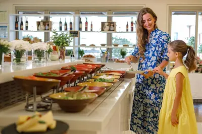 a woman and a little girl preparing food in a kitchen at Louis Althea Beach in Protaras