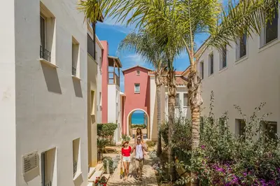 two people walking down a street between buildings at Louis Althea Beach in Protaras