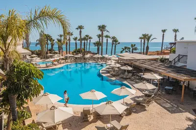 an overhead view of a swimming pool with umbrellas and the ocean at Louis Althea Beach in Protaras