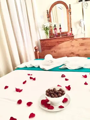 a table with a bowl of chocolate hearts on a bed at Estia Vasilis Manoli in Ayia Napa