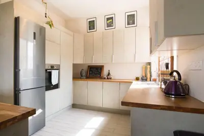 a kitchen with white cabinets and a stainless steel refrigerator at Vas' Penthouse in Nicosia