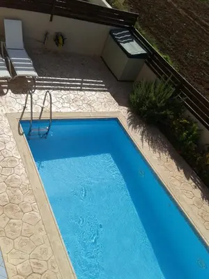 a small blue swimming pool in a yard at Marias Villa in Protaras