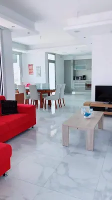 a living room with a red couch and a table at Villa Spathele in Paralimni