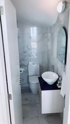 a white bathroom with a toilet and a sink at Villa Spathele in Paralimni