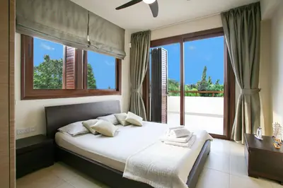 a bedroom with a bed and a large window at Villa Leonidas in Protaras