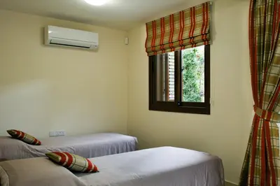 a room with two twin beds and a window at Villa Leonidas in Protaras
