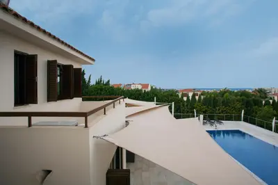 a white house with a swimming pool and a balcony at Villa Leonidas in Protaras