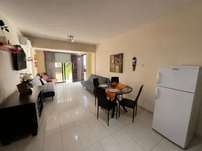 a kitchen and living room with a table and a refrigerator at George Apartments in Ayia Napa