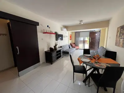 a dining room and living room with a table and chairs at George Apartments in Ayia Napa