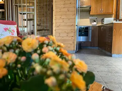 a kitchen with a table with yellow flowers in the foreground at Vasiliou House Krimenos in Khandria