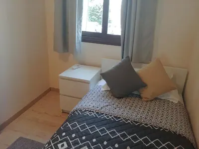 a bedroom with a bed with two pillows and a window at Galatex Beach Apartment in Limassol